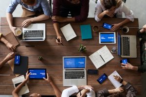 faceless team at a table with laptops and pads